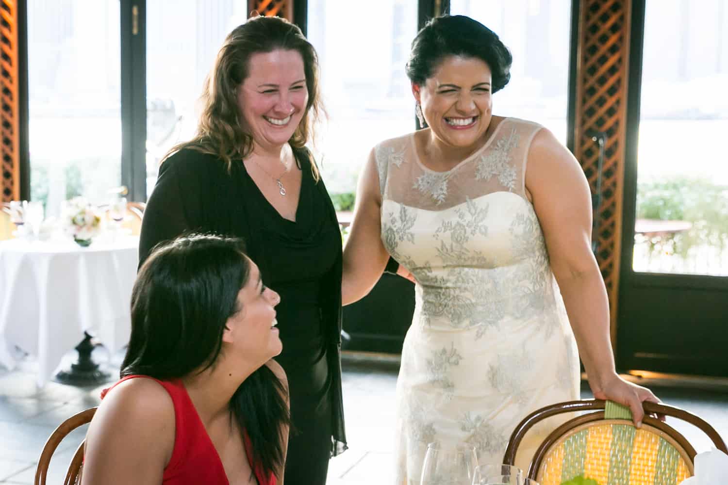 Bride chatting with two female guests at a River Café wedding in Brooklyn