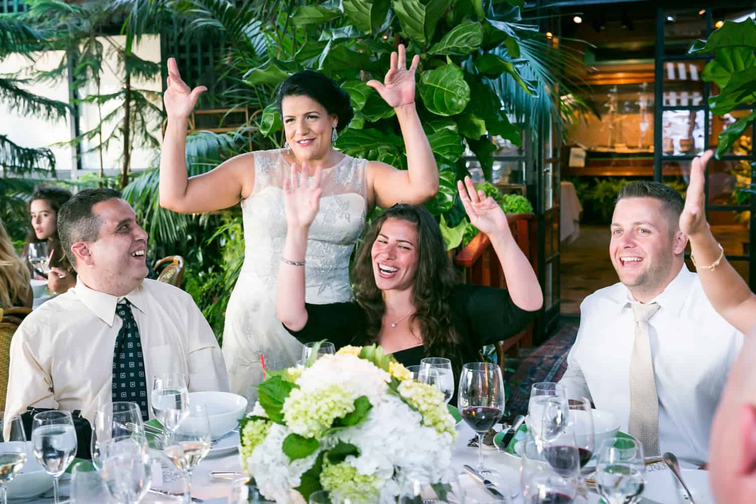 Bride raising hands with guests at a River Café wedding in Brooklyn
