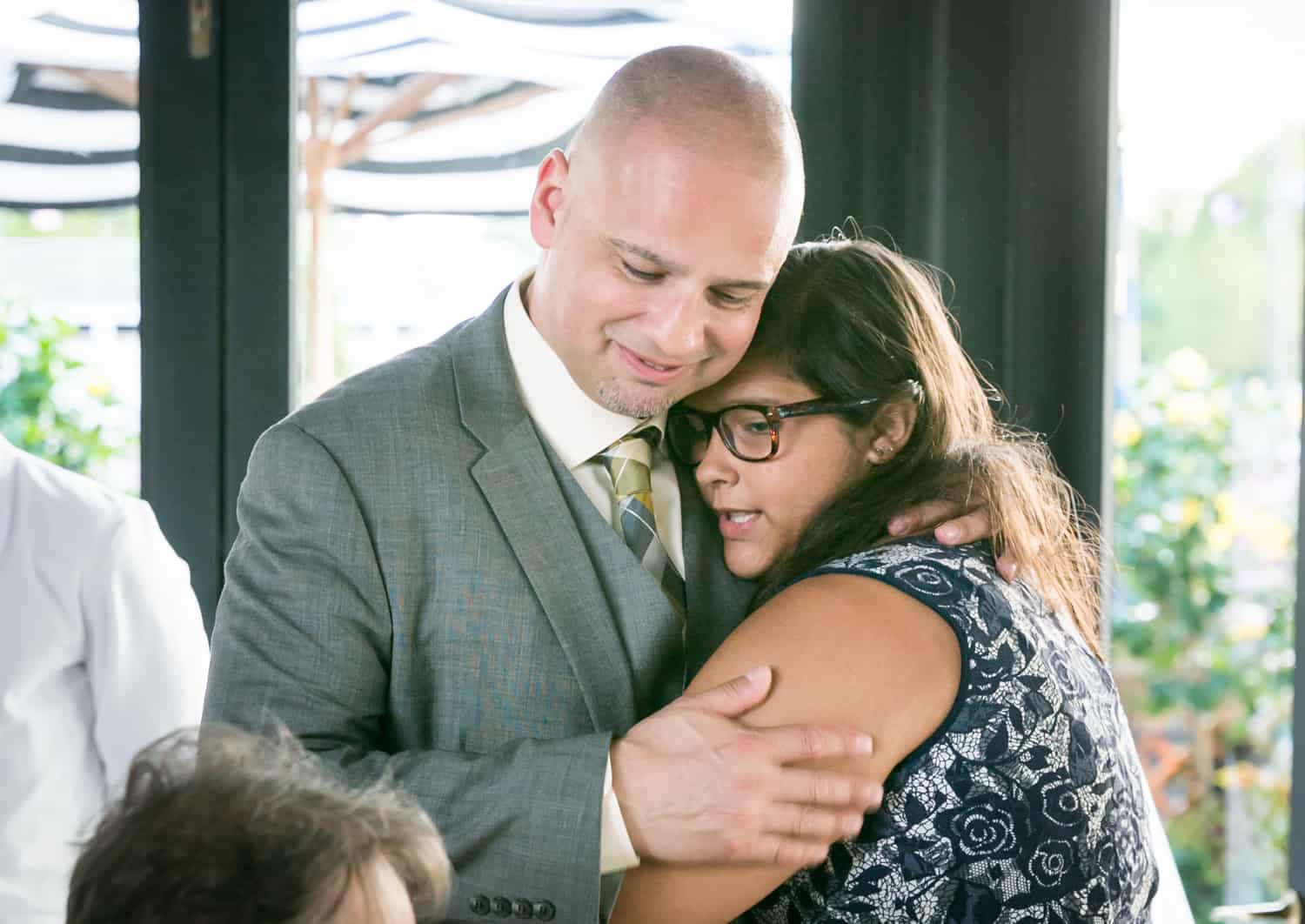 Groom hugging daughter at a River Café wedding in Brooklyn