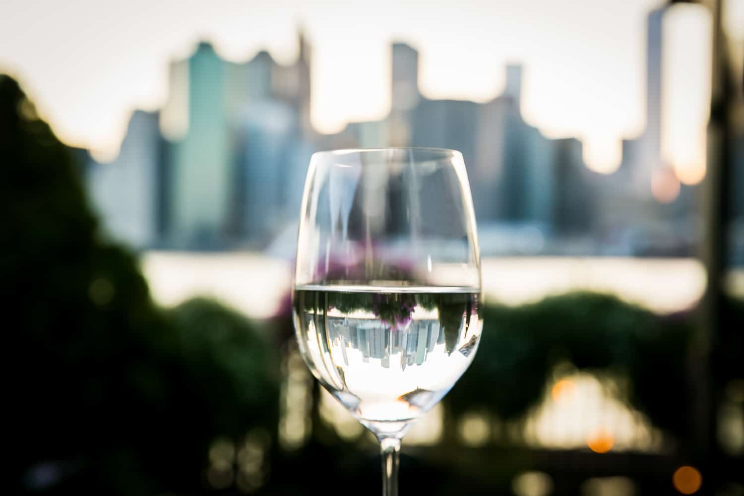 Wine glass filled with water with NYC skyline reflected