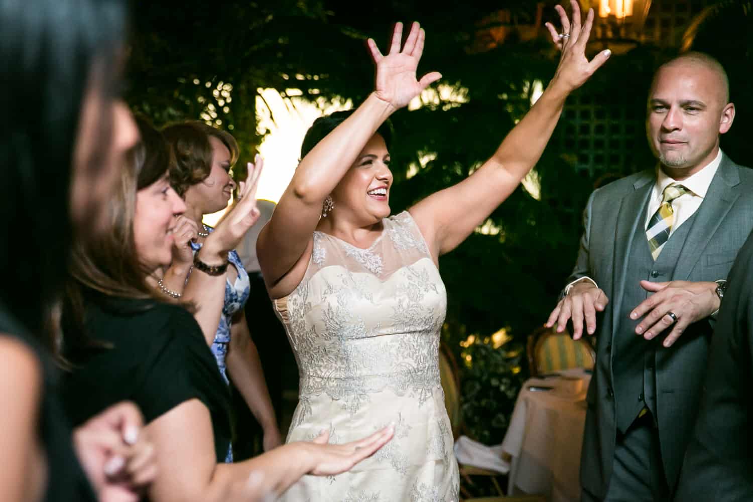 Bride dancing with arms raised at a River Café wedding in Brooklyn