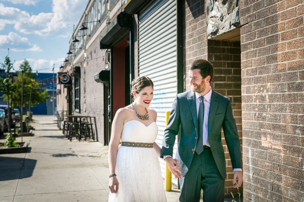 Bride and groom walking hand-in-hand on Gowanus sidewalk