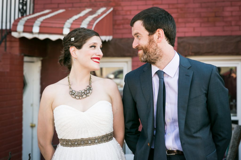 Bride and groom in front of brick apartment in Gowanus