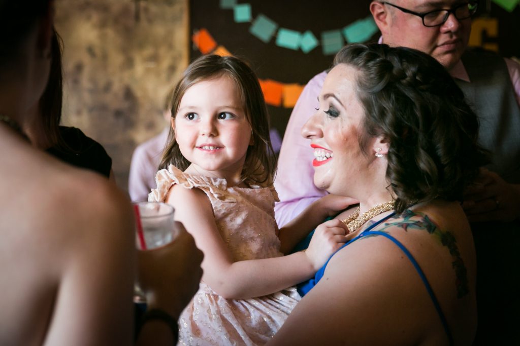 Woman holding smiling little girl at a Bell House wedding anniversary party