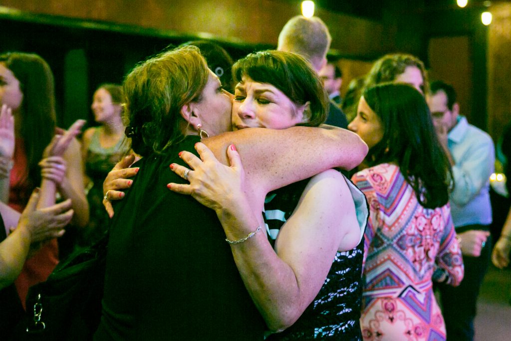 Mother of the bride hugging guest at a Bell House wedding anniversary party