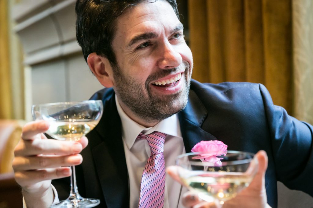 Close up on groom drinking champagne