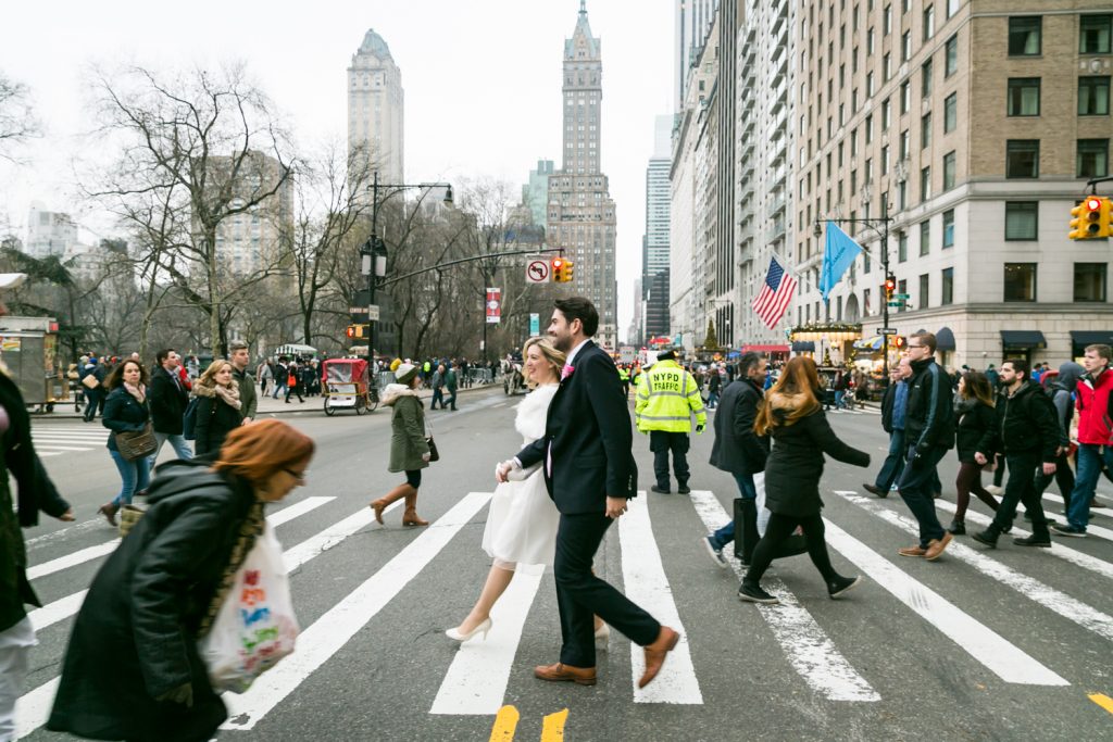 Bride and groom walking in crosswalk on NYC street