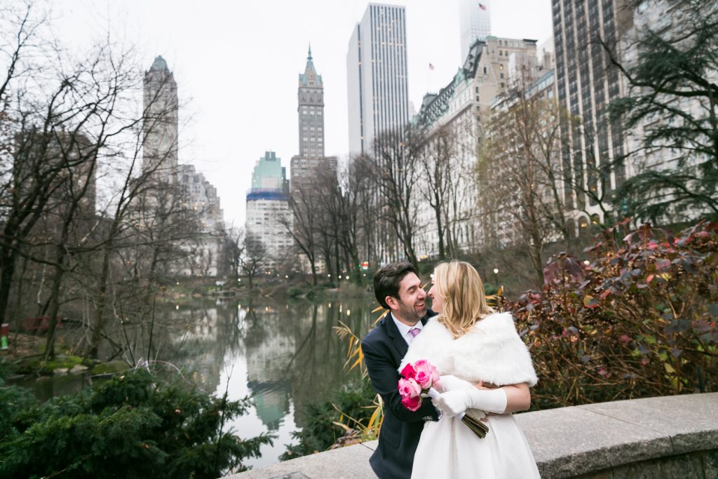 Bride and groom hugging by Central Park pond