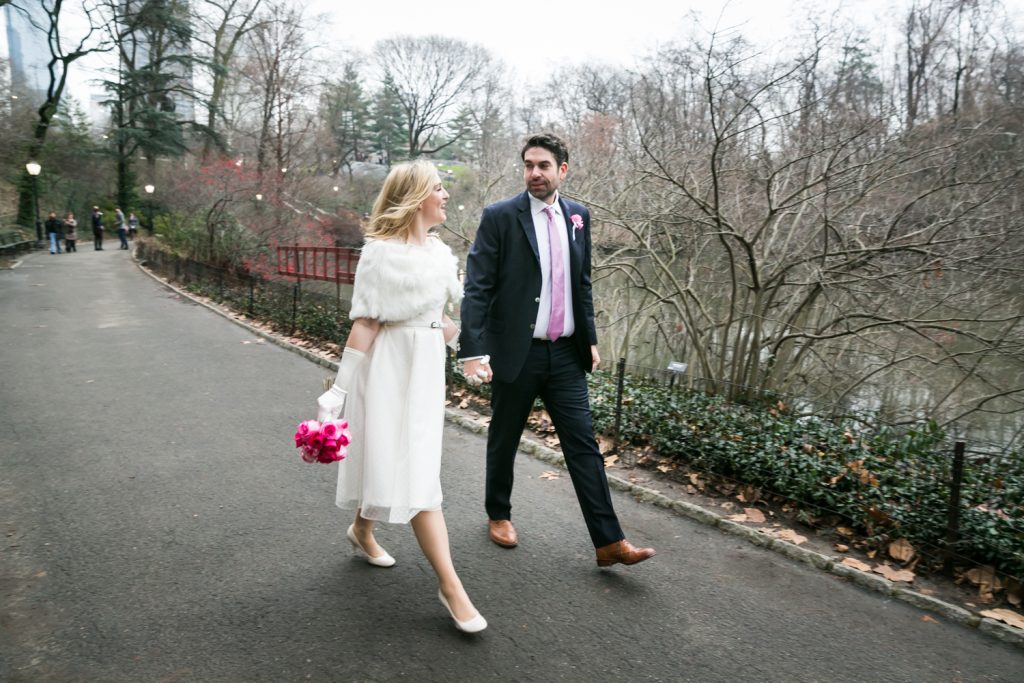 Bride and groom walking hand-in-hand in Central Park