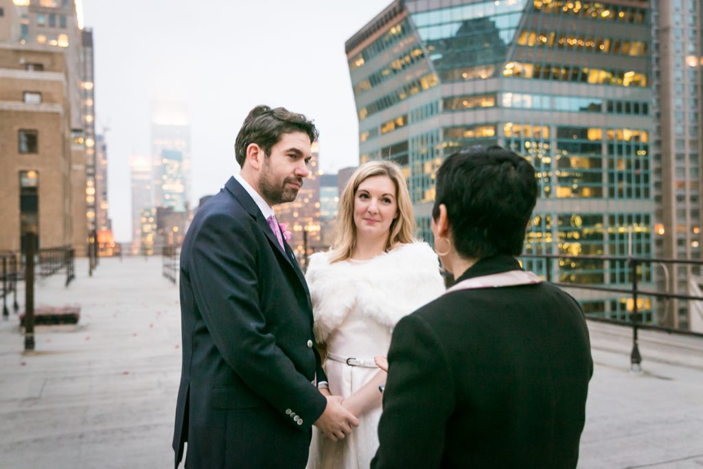 Bride and groom listening to officiant at a Grand Hyatt Hotel rooftop wedding