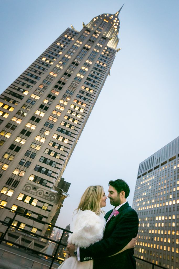 Bride and groom hugging in front of Empire State Building at a Grand Hyatt Hotel rooftop wedding