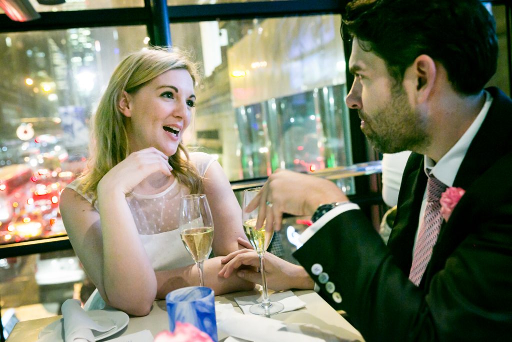 Bride and groom drinking in restaurant after Grand Hyatt Hotel rooftop wedding