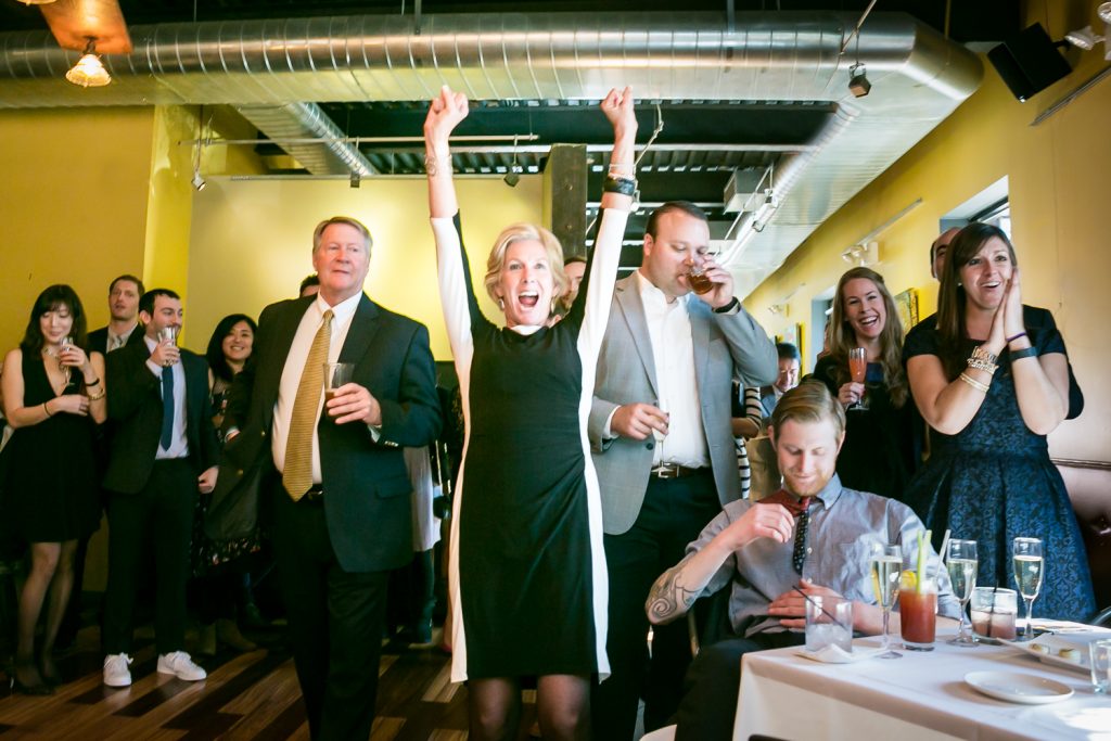 Woman cheering with arms raised at an Astoria restaurant wedding