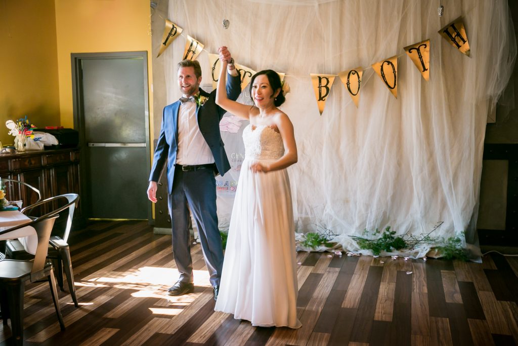 Bride and groom raising hands at an Astoria restaurant wedding