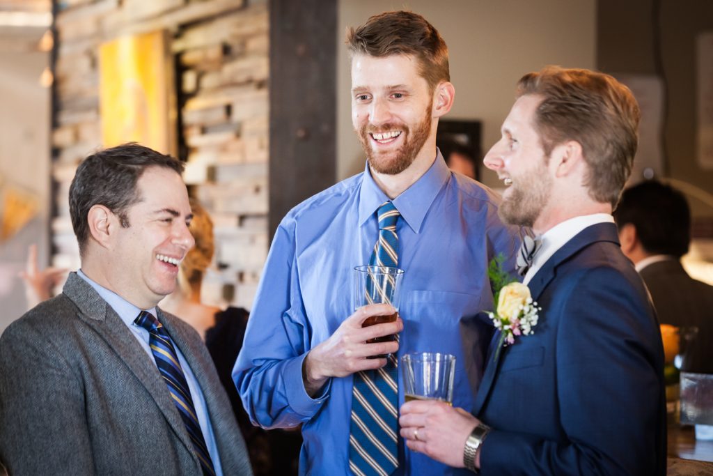 Three male guests laughing at an Astoria restaurant wedding
