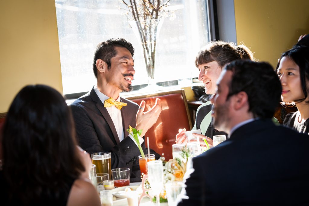 Guests talking in front of window at an Astoria restaurant wedding