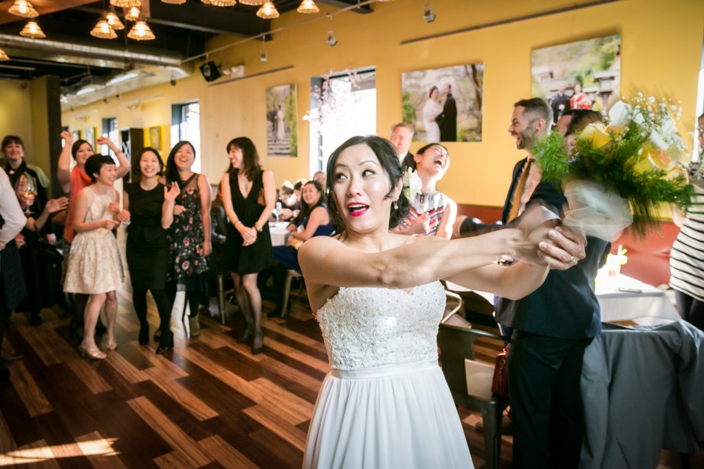 Bride about to throw bouquet at an Astoria restaurant wedding