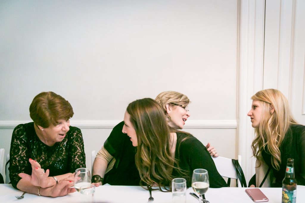 Four female guests talking at table during Maison May wedding reception