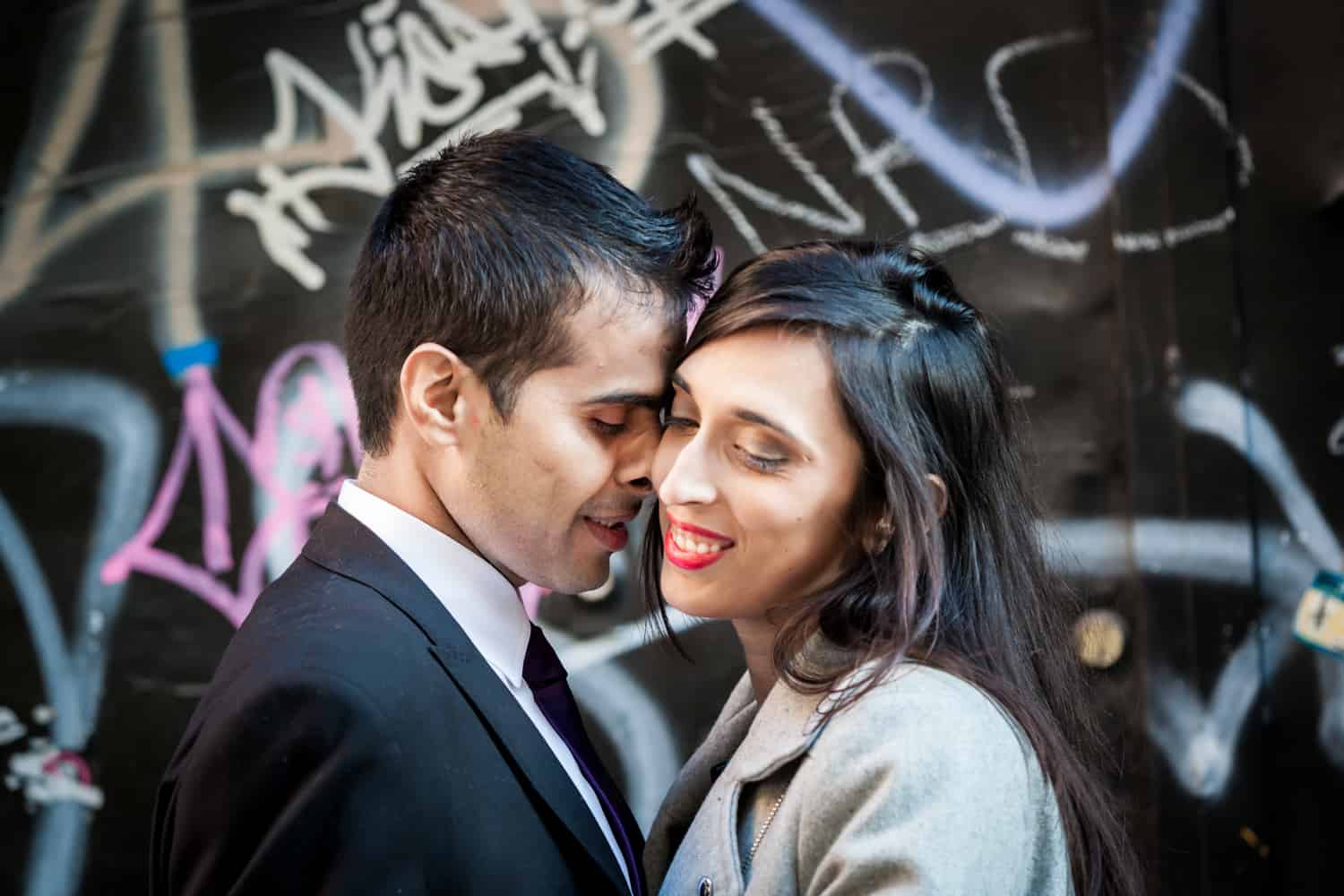 Couple hugging in front of graffiti wall in Tribeca