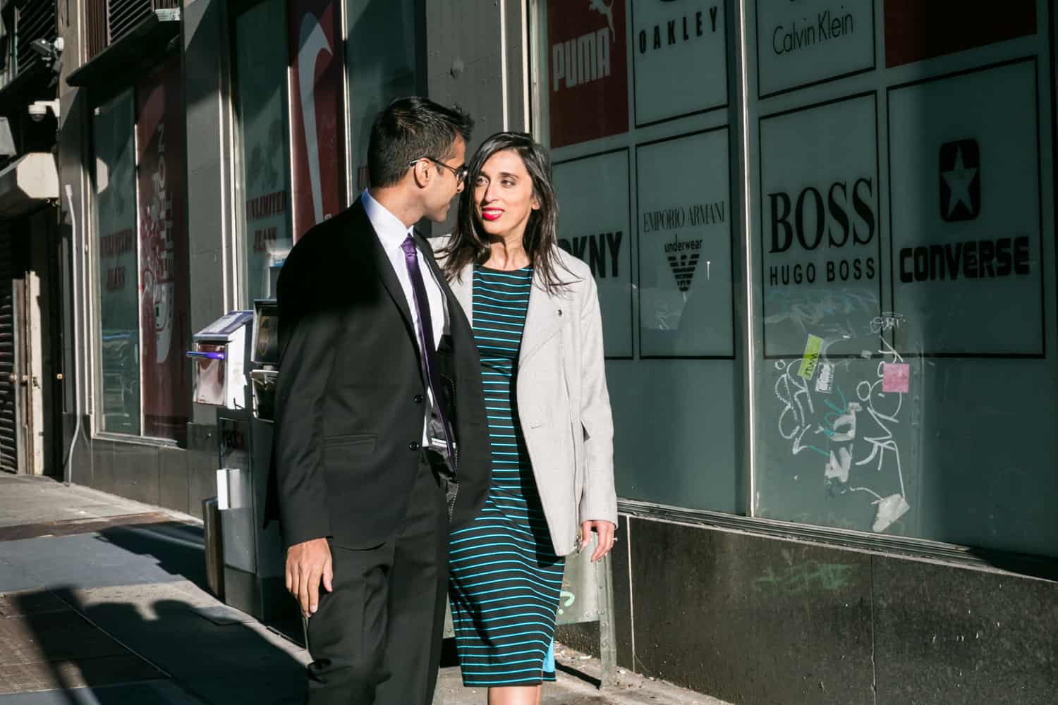 Couple walking down Tribeca sidewalk during engagement shoot