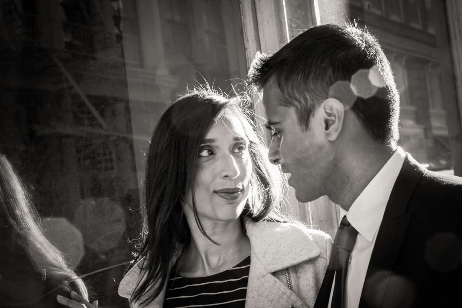 Black and white photo of engaged couple walking down street in Tribeca