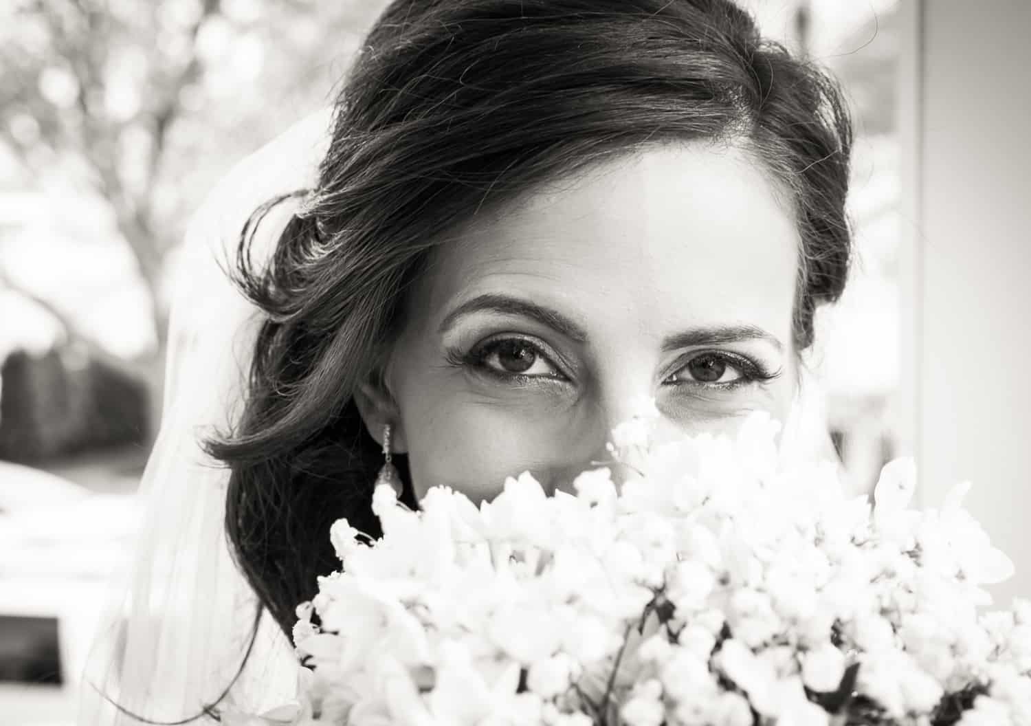 Black and white photo of bride looking over bouquet