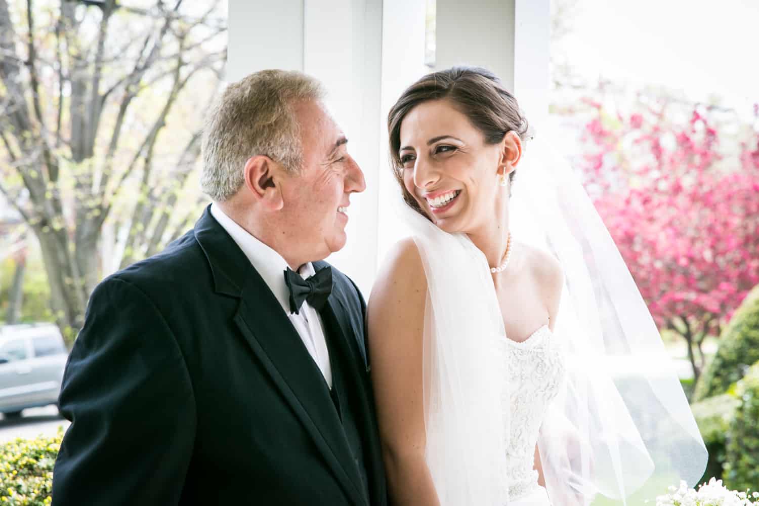 Bride and father laughing on porch for an article called 'Do you need a second photographer?'