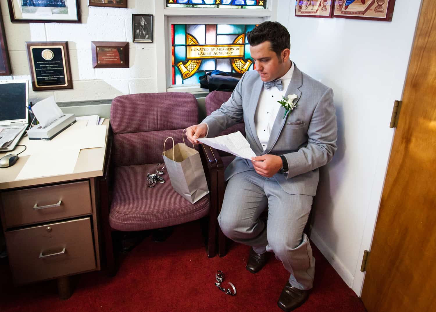 Groom sitting in church reading letter