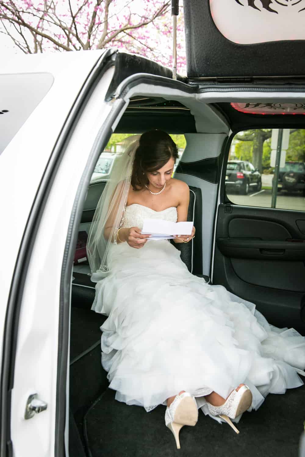 Bride sitting in limo reading letter