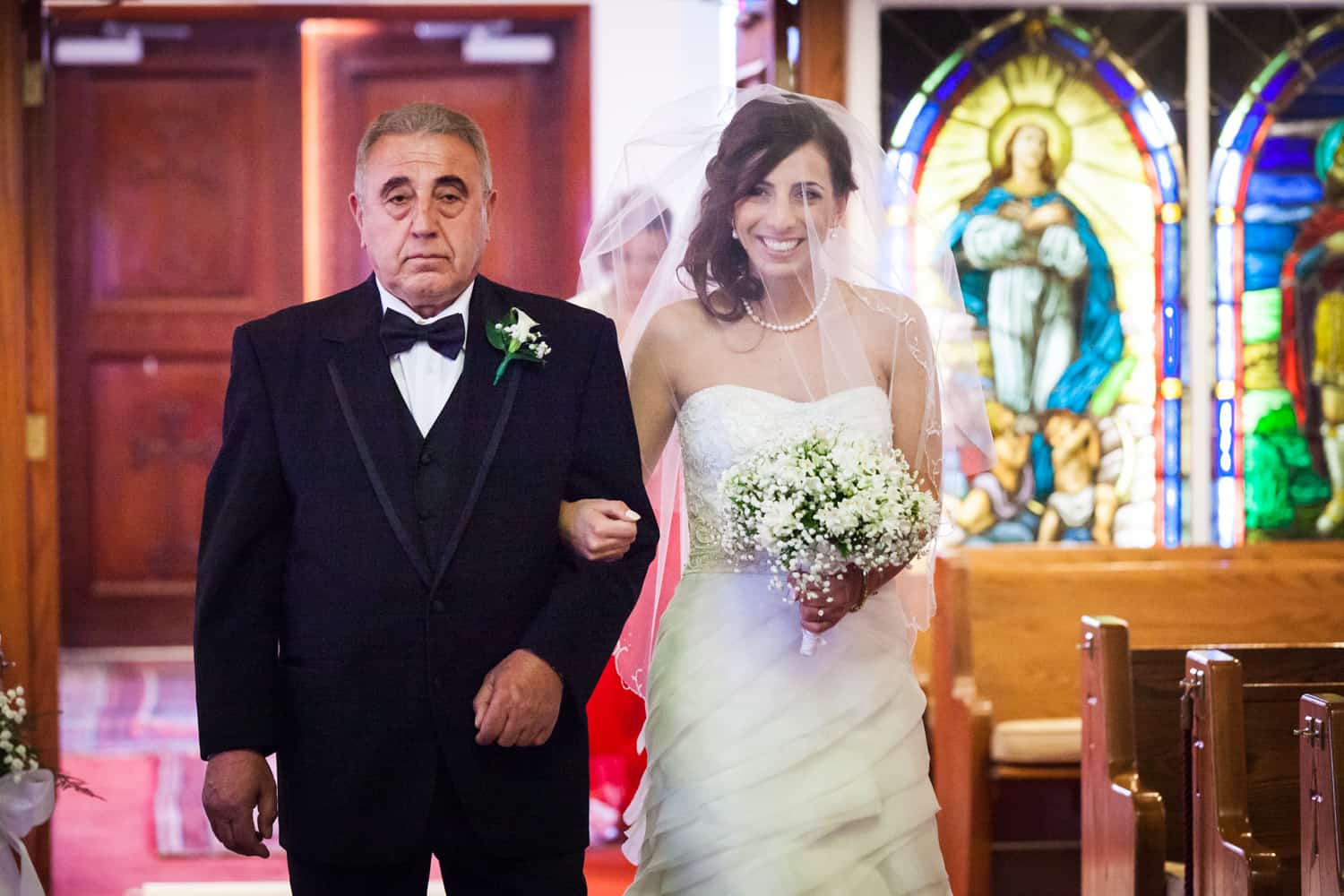 Bride and father walking down aisle in Eastern Orthodox wedding ceremony