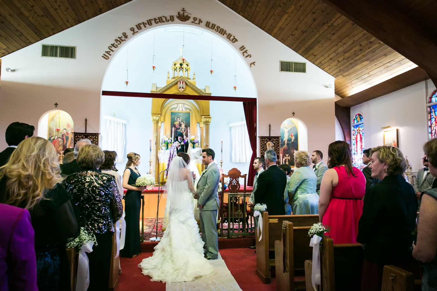 Bride and groom exchanging vows in Eastern Orthodox wedding ceremony