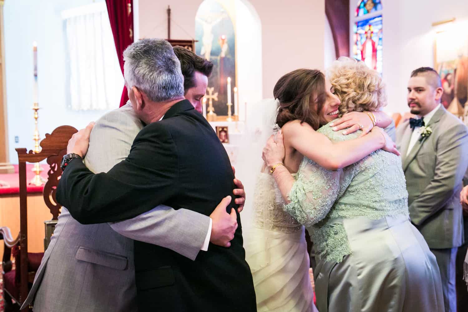 Bride and groom hugging guests after Eastern Orthodox wedding ceremony