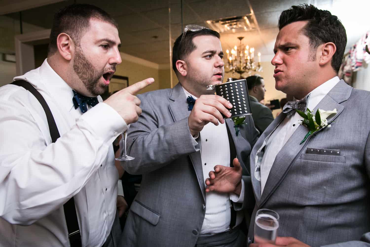 Groomsmen pointing at groom in bridal suite