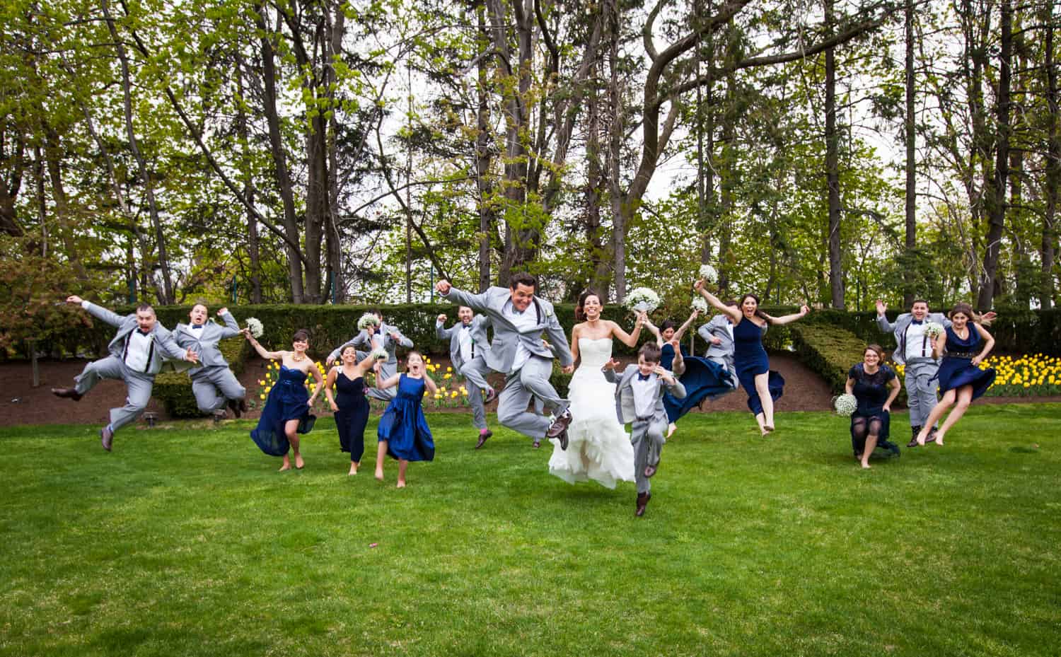 Bridal party jumping on grass for an article called 'Do you need a second photographer?'