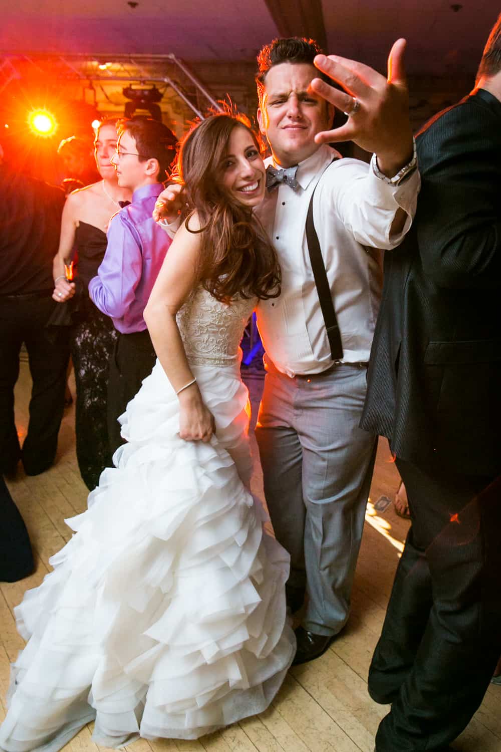 Bride and groom gesturing to camera during Manor wedding reception