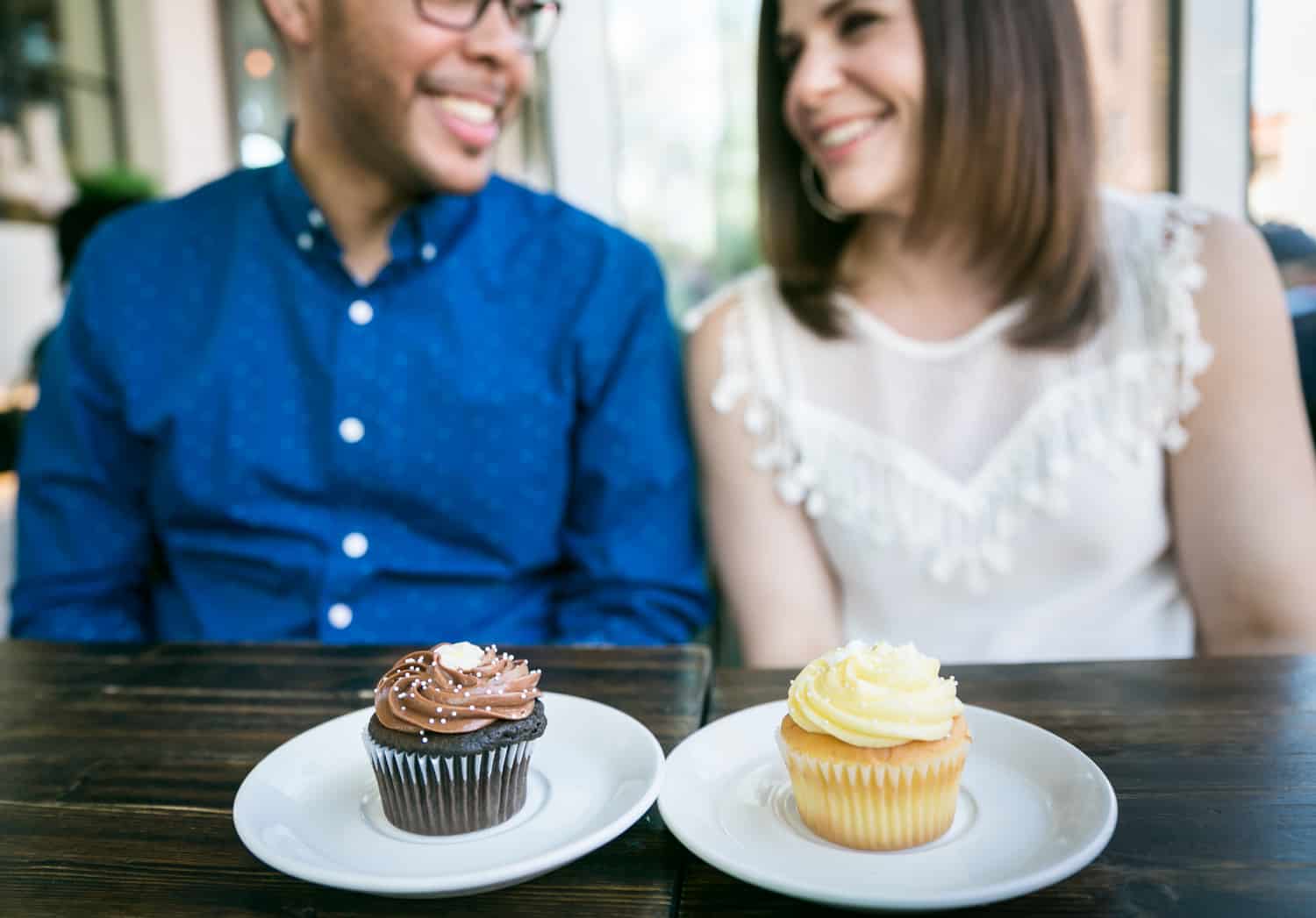 Two plates with cupcakes in front of a couple during an Astoria Park engagement shoot