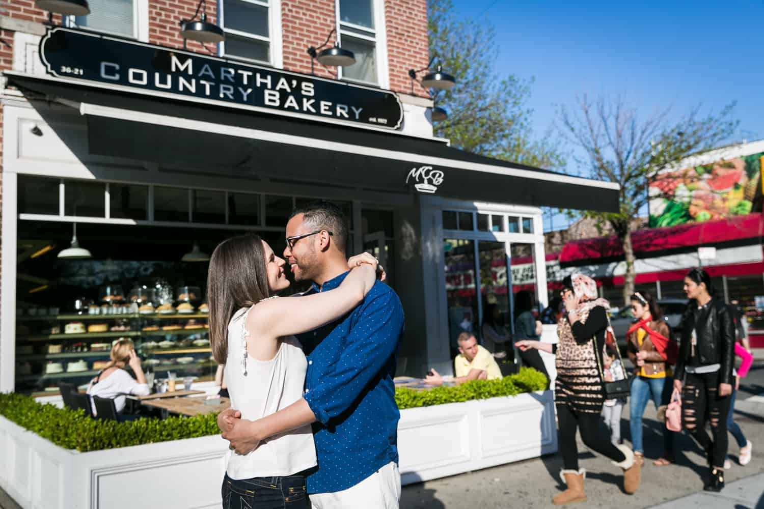 Couple kissing in front of Martha's Country Bakery in Astoria
