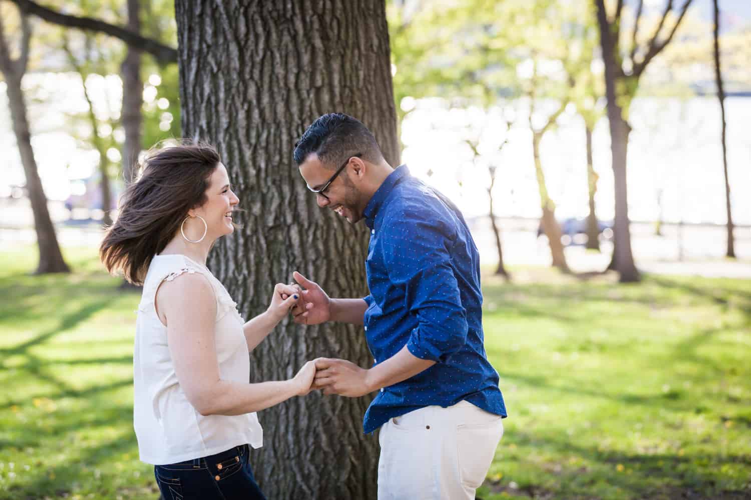 Couple dancing in front of tree during an Astoria Park engagement shoot