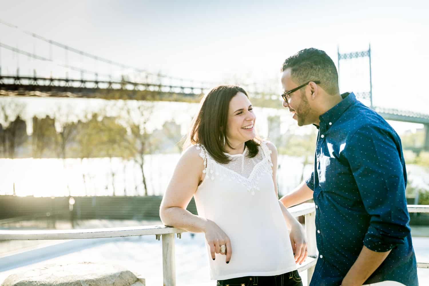 Couple leaning against railing during an Astoria Park engagement shoot