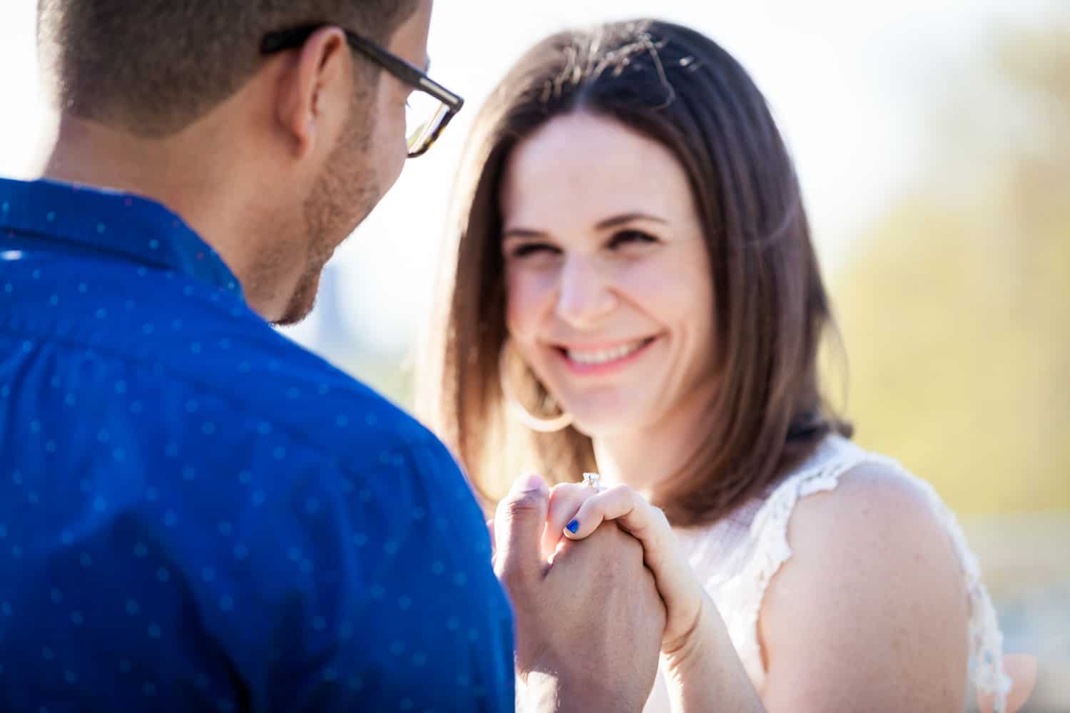 Woman showing engagement ring to man during an Astoria Park engagement shoot