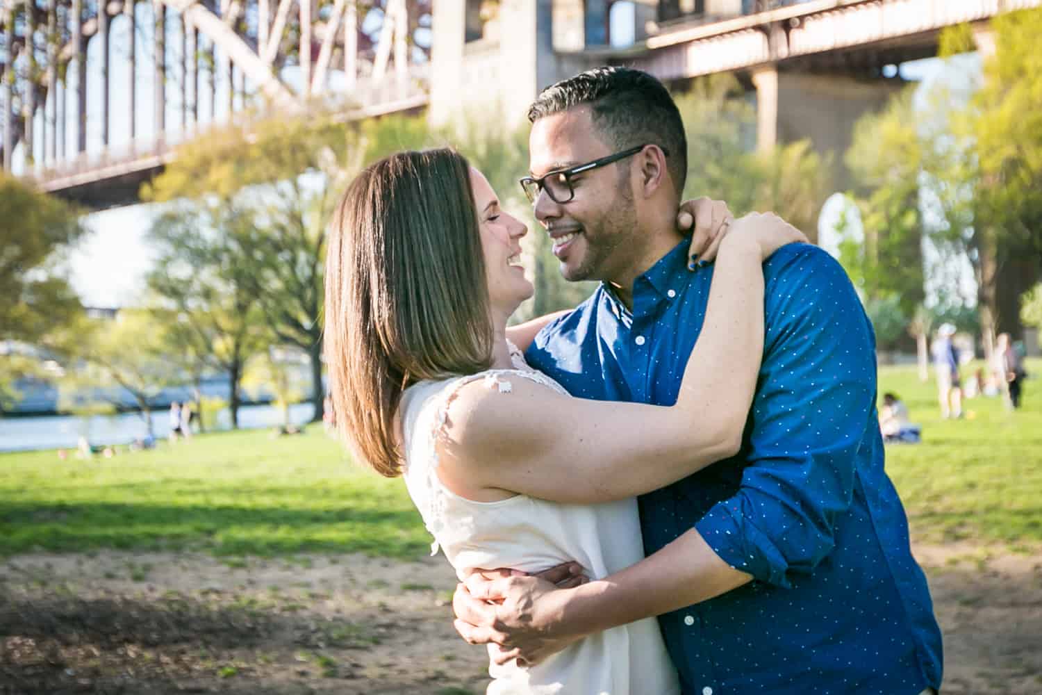 Couple dancing in front of Hellgate Bridge during an Astoria Park engagement shoot