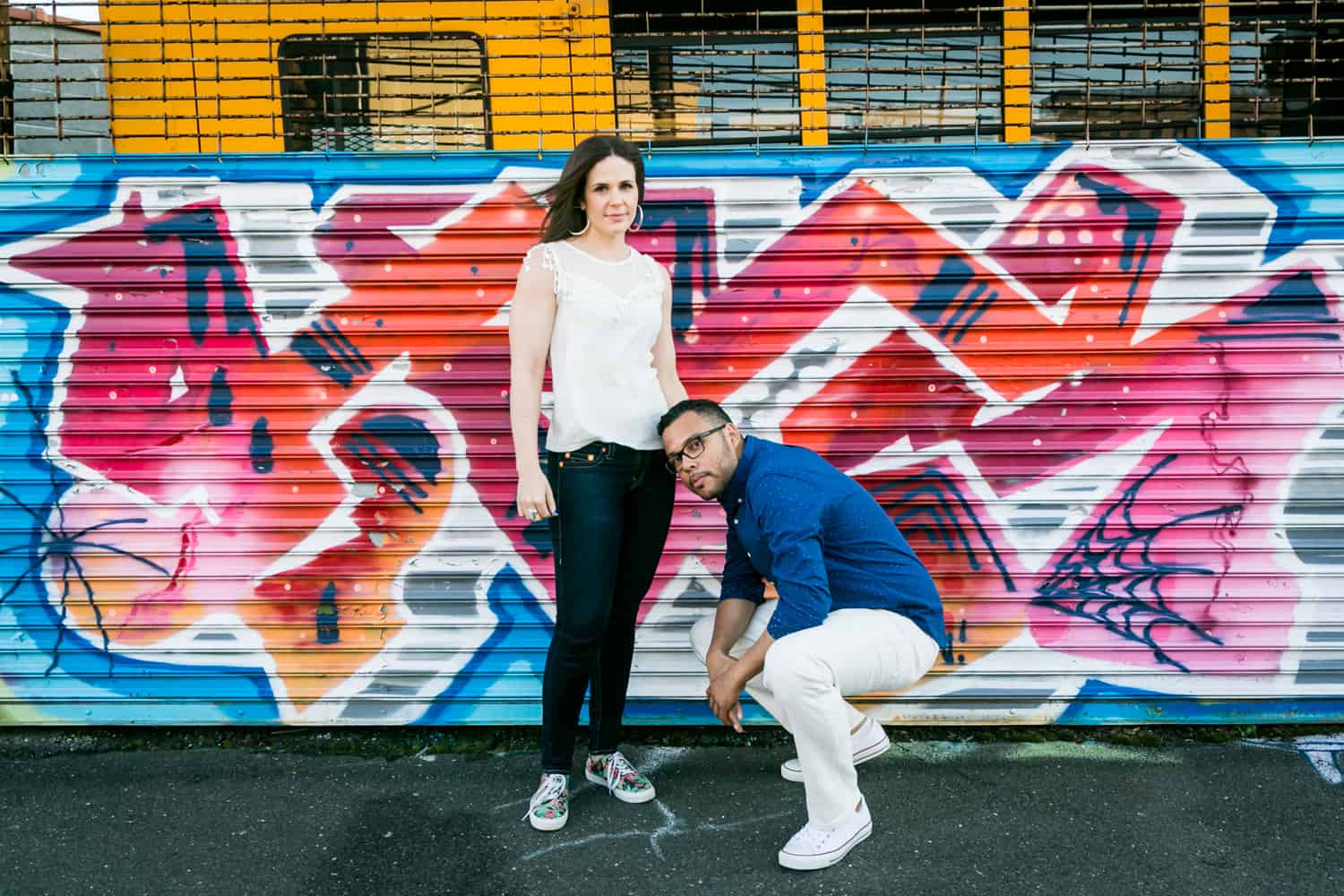 Couple in front of colorful graffiti during an Astoria Park engagement shoot