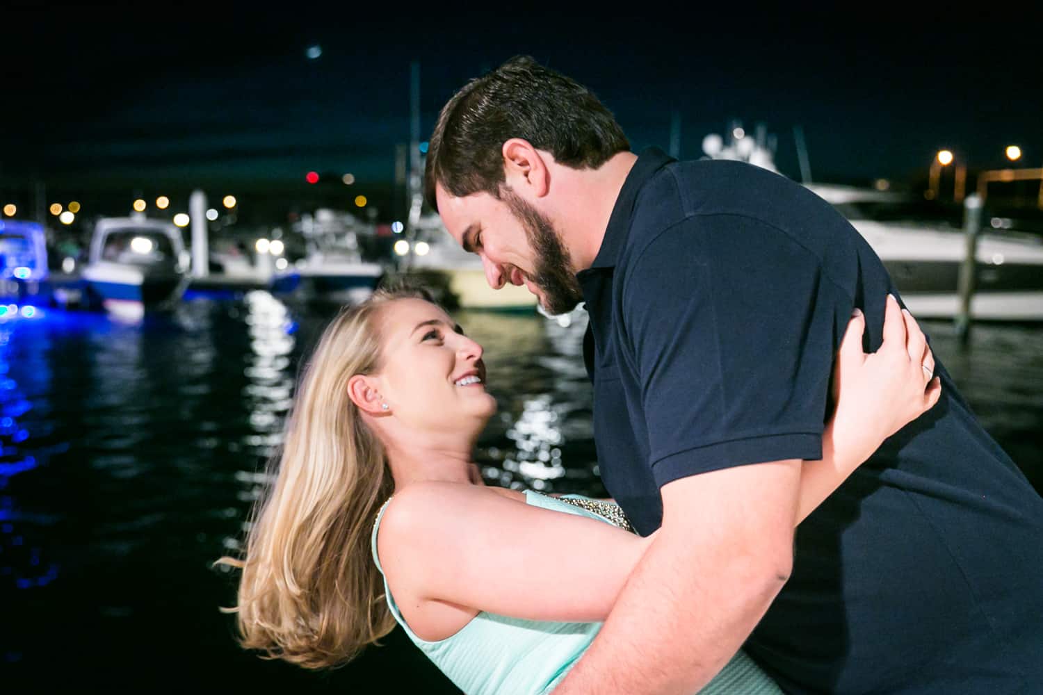 Couple dancing in front of water at night during a Coral Cove Park engagement shoot