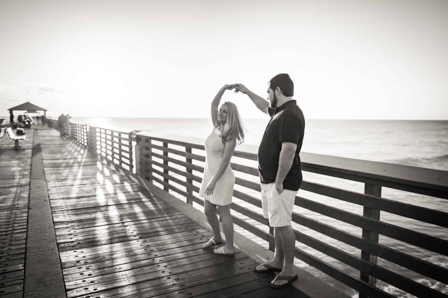 Black and white photo of couple dancing on dock