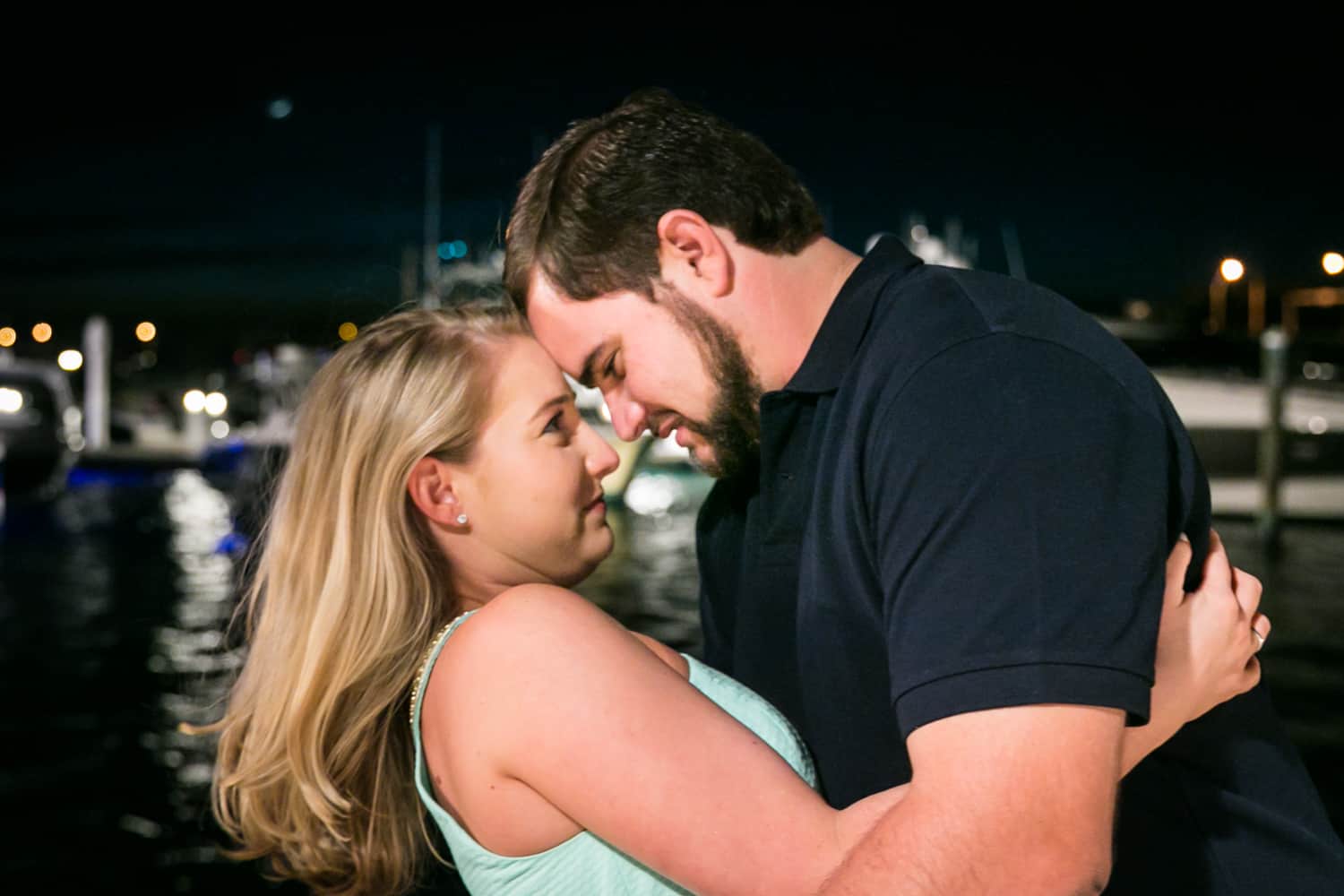 Couple touching foreheads at night during a Coral Cove Park engagement shoot