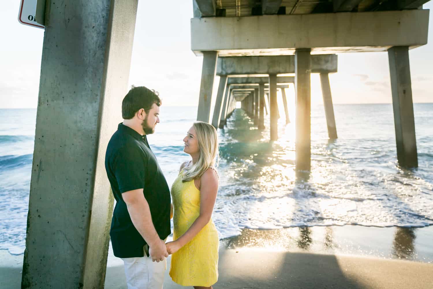 Couple holding hands under pier 