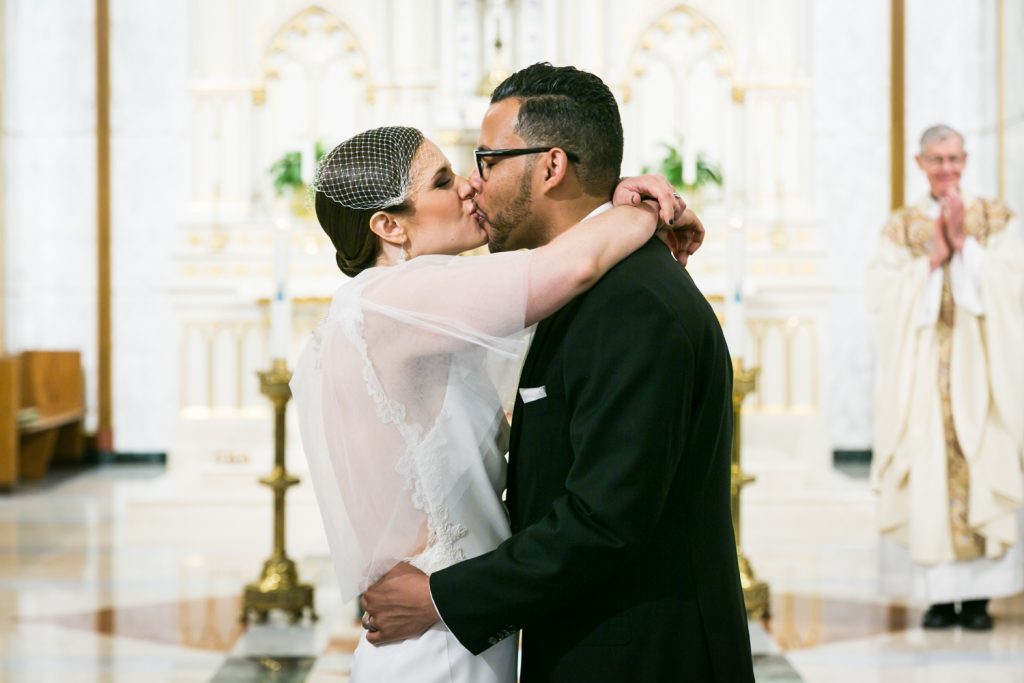 Bride and groom kissing after Our Lady of Mt. Carmel Church wedding ceremony