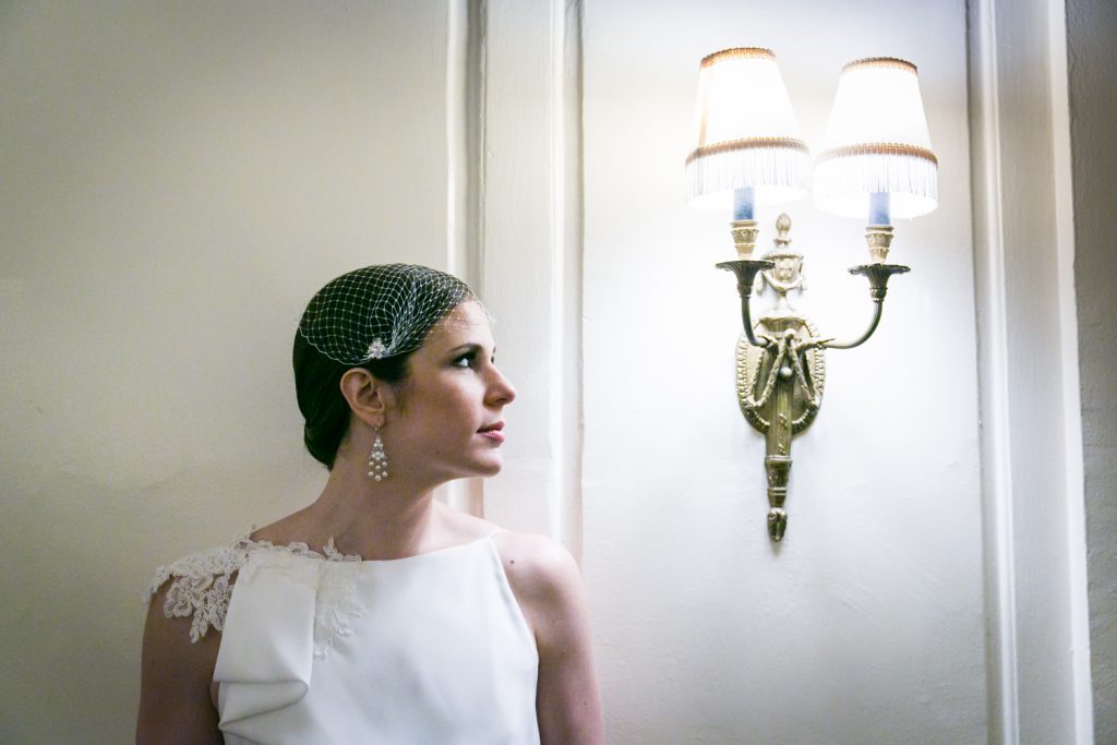 Bride looking at wall sconce in Roosevelt Hotel wedding photo