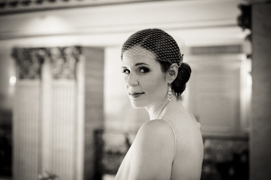 Black and white photo of bride looking over her shoulder in Roosevelt Hotel wedding photo