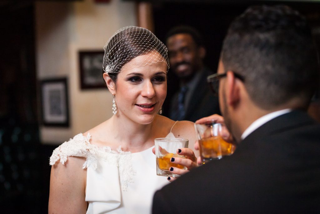 Bride looking at groom while drinking whiskey